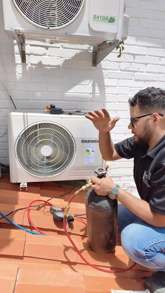 Técnico de Fondach cargando gas refrigerante R-410A en un equipo split